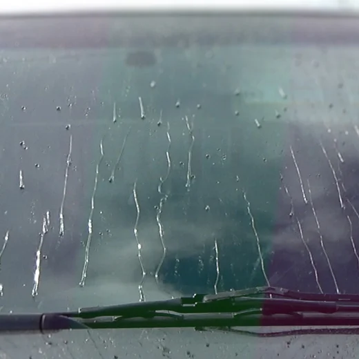 Rain is shedding off the windshield we just polished.